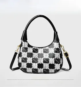 Detail of black contrast handbag with silver wavy checkered pattern and round top handle