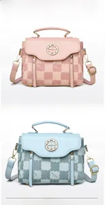Detail of pink and blue handbags featuring gold clover logos and monogram embossing