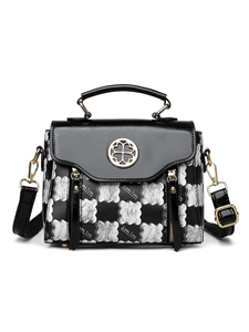 Detailed close-up of textured leather handbag with silver cloud pattern and clover buckle