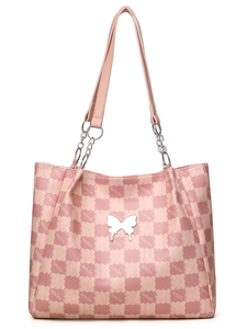 Détail de l'ornement papillon argenté et du sac cabas en cuir à motifs de cœurs