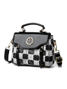 Detail view of vintage handbag with clover buckle and textured pattern strap