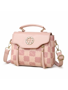 Detailed view of pink patterned handbag featuring gold circular buckle and tassel zippers