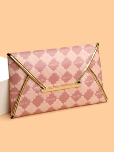 Vue macro de la pochette enveloppe rose avec motifs floraux et finitions en métal doré