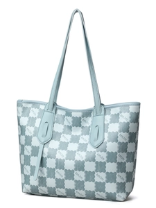 Detail view of light blue tote bag with clover patterns and long shoulder straps