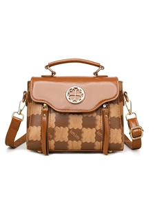 Detail of vintage brown plaid handbag with gold clover buckle and leather handle