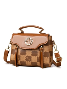 Macro detail of brown jacquard handbag with kmjm pattern and golden floral clasp