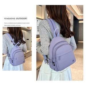 Detail of lavender nylon mini backpack with adjustable straps and multiple compartments
