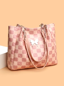 Gros plan détaillé du sac cabas rose avec boucle papillon argentée et motifs d'ours