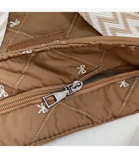Détail macro de la fermeture éclair en métal et broderie d'étoiles sur sac matelassé