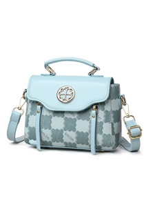 Detail of light blue crossbody bag with clover embossed texture and gold metal buckle