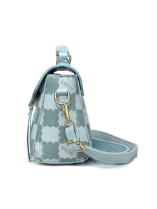 Detail of light blue crossbody bag with kmJm geometric floral pattern and gold hardware