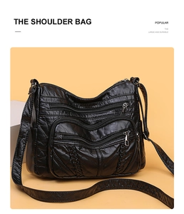 Close-up of black PU leather shoulder bag with multiple zippers and woven detail