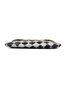 Détail d'une pochette enveloppe noire avec motifs en croix blancs et accents dorés