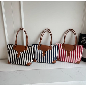 Detailed comparison of striped canvas tote bags in black, blue and red with leather straps