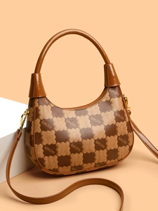 Close-up of contrast color handbag showing clover pattern texture and metal hook