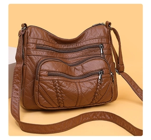 Close-up of vintage brown PU leather bag with multi-zipper pockets and woven detail