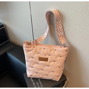 Détail du sac cabas rose matelassé avec broderie de nœuds et bandoulière large à motifs