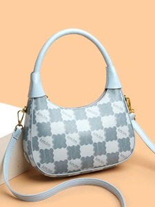 Close-up of kmJm monogram patterns and golden metal hardware on light blue shoulder bag