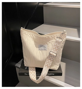 Gros plan sur le sac fourre-tout beige plissé avec bandoulière en jacquard à motifs géométriques