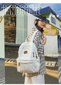 Outdoor shot of a white corduroy backpack showing large capacity and soft texture
