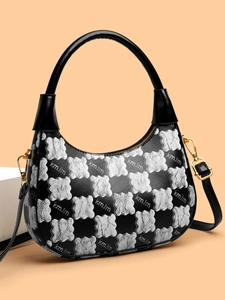 Detailed view of the black and white contrast crescent bag with golden bear hardware