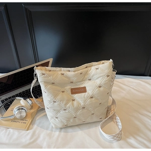 Détail du sac fourre-tout matelassé avec broderie florale et large bandoulière à motifs
