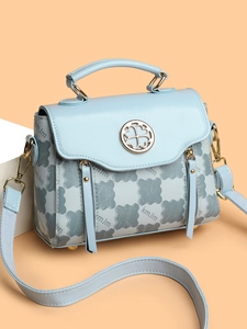Detail of light blue vintage handbag featuring a petal-shaped metal buckle and kmJm pattern