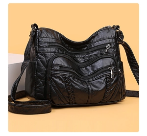 Detail of black pleated PU shoulder bag showing multiple zippers and braided straps