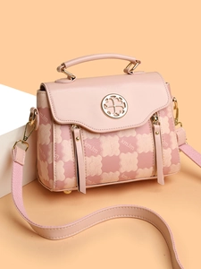 Detailed view of pink floral shoulder bag with bear print and clover metal logo