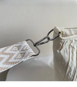 Détail du sac cabas en toile blanc cassé avec boucle en métal argenté et bandoulière jacquard