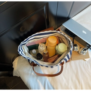 Spacious interior of striped canvas tote bag showing laptop and daily essentials