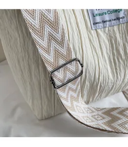 Détail de la bandoulière réglable à motifs sur le cabas blanc avec boucle argentée