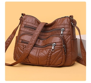 Close-up of dark brown PU leather crossbody bag featuring multiple zipper pockets and texture