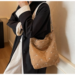 Détail du sac cabas matelassé marron avec nœuds blancs et écusson en cuir Perfect Lady