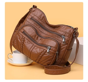 Detailed close-up of brown PU leather bag with woven design and textured zipper pockets
