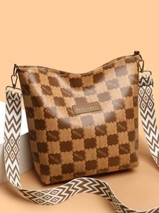 Détail du sac seau marron à motif ours avec large bandoulière géométrique et logo