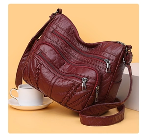 Detail of red vintage PU leather tote with multi-zipper pockets and woven accents