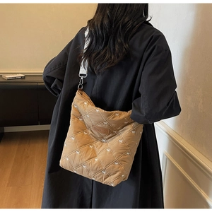 Détails du sac bandoulière matelassé marron avec petits nœuds blancs et mousqueton