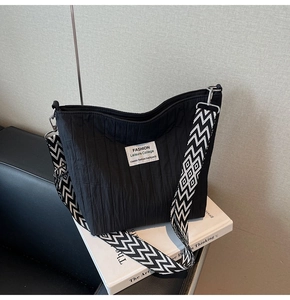 Détail du sac cabas en nylon matelassé noir avec bandoulière à motifs géométriques