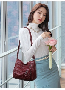 Deep red PU leather crossbody tote bag with zipper pockets worn by model