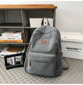 Detailed close-up of grey corduroy backpack showing high-quality texture and side pockets