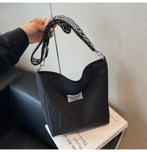 Gros plan d'un sac fourre-tout noir matelassé avec étiquette mode et bandoulière large