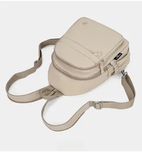 Detailed top view of beige nylon backpack showing front pockets and adjustable straps