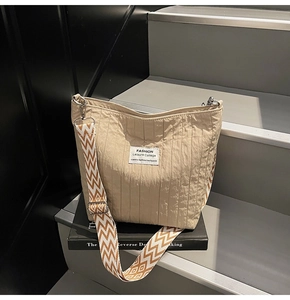 Détail du sac hobo beige en tissu texturé avec bandoulière large en jacquard à zigzag