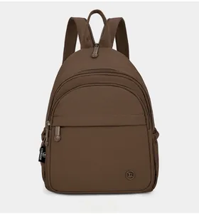 Front view of brown nylon backpack featuring multi-layer zippers and side logo detail
