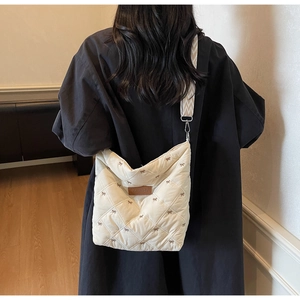 Détail du sac matelassé crème avec broderie nœud et logo de la marque Pioneer Lily