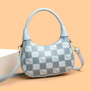 Chic light blue hobo bag with contrast floral pattern and gold hardware on orange background