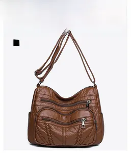 Detailed front view of brown PU tote bag with triple zipper pockets and woven sides