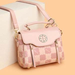 Pink PU leather handbag with bear print and metal clover logo shown from a 45-degree angle