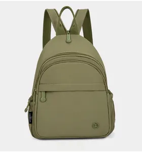 Front detail of olive green mini nylon backpack showing zippers and side brand label